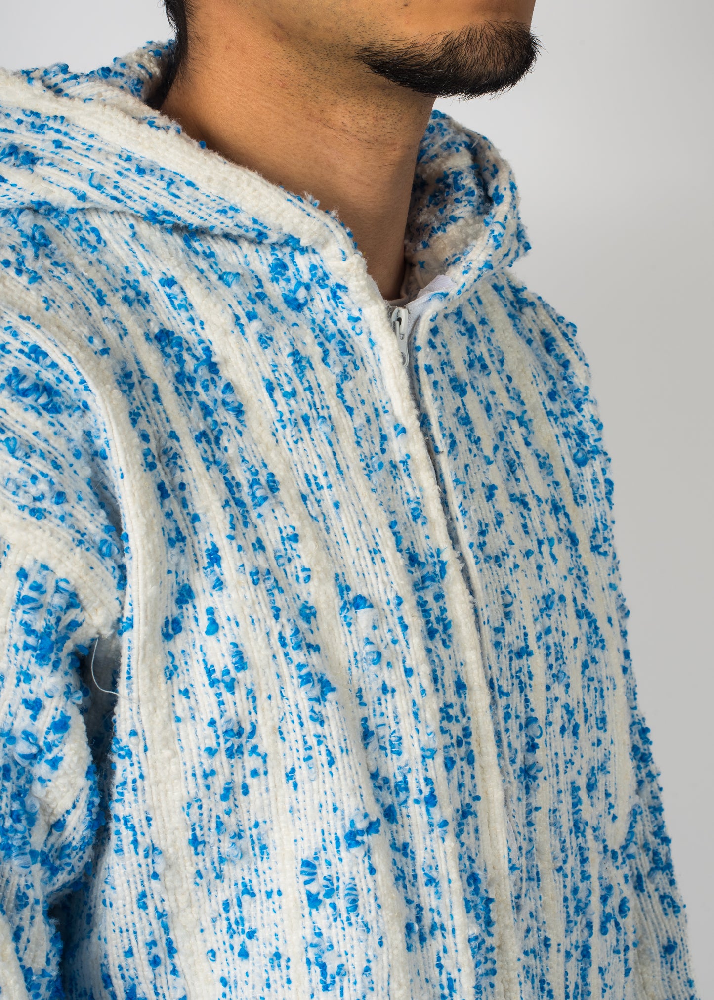 Mannequin avec une veste Barbary Coast longue, blanche avec des milliers de points bleu tissé à la main.