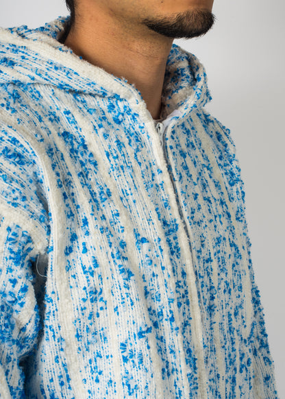 Mannequin avec une veste Barbary Coast longue, blanche avec des milliers de points bleu tissé à la main.