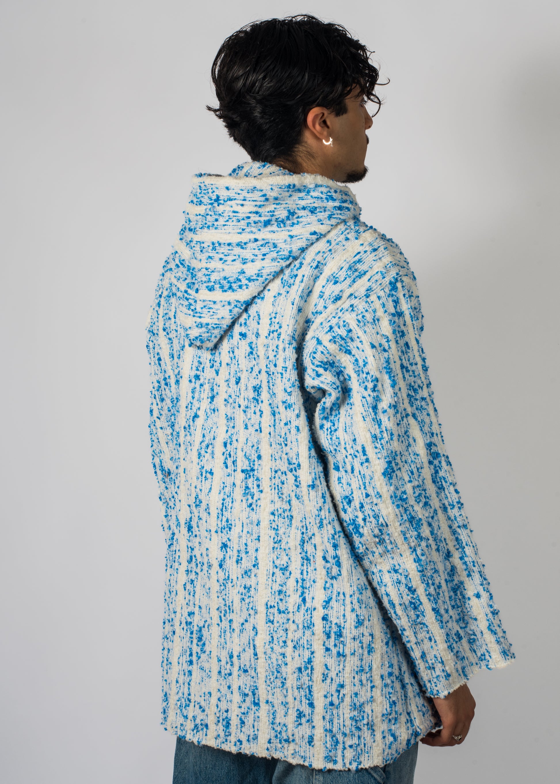 Mannequin avec une veste Barbary Coast longue, blanche avec des milliers de points bleu tissé à la main.