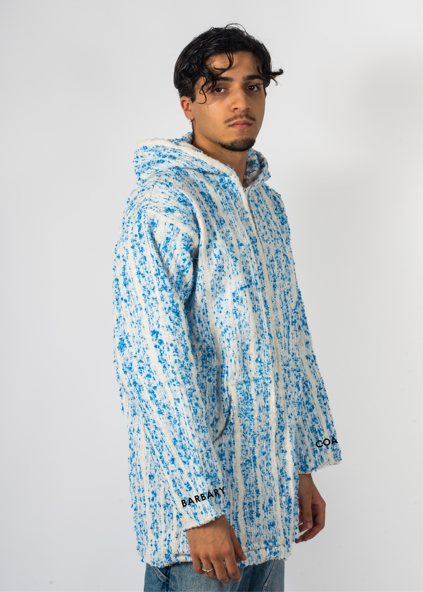 Mannequin avec une veste Barbary Coast longue, blanche avec des milliers de points bleu tissé à la main.